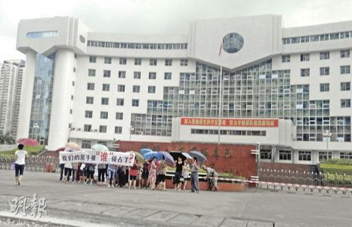 橫額寫着「我們的房子被誰侵佔了?」