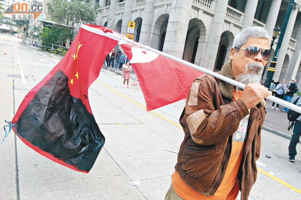 社運人士古思堯塗黑國旗及區旗,以表達對中國及特區政府的不滿。